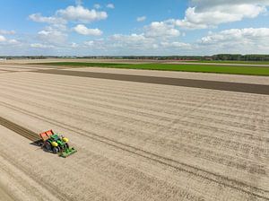 Traktor beim Pflanzen von Pflanzkartoffeln auf einem Feld im Frühling
