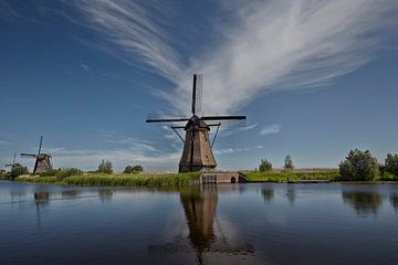 Beroemde Nederlandse houten windmolens in Kinderdijk Holland. Zonnige zomeravond op het platteland.  van Tjeerd Kruse