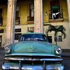 Groene oldtimer voor geel gebouw in Havana, Cuba sur Jutta Klassen