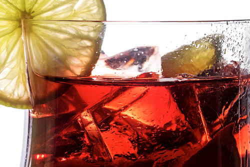 roter Cocktail, Nahaufnahme eines Mischgetränks aus Beeren, Limette und Eis, mit oder ohne Alkohol, 
