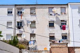 White facade with white satellite dishes and flapping wax under Spanish bright sun and blue sky by Studio LE-gals