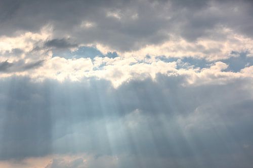 The sun is bursting through a tear in the sky