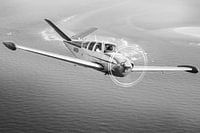 Vintage Beechcraft Bonanza airplane over the sea