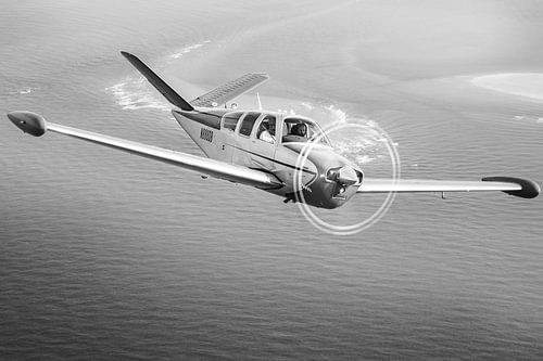 Vintage Beechcraft Bonanza Flugzeug über dem Meer
