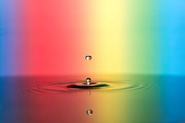 Colorful water drop falls into the water