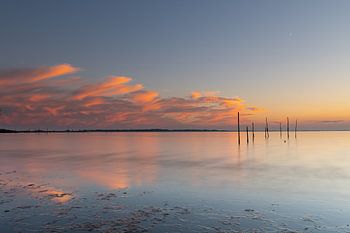 Reflektierender Sonnenuntergang mit Pfosten