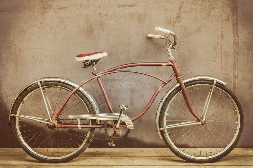 Vélo de croisière d'époque rouillé sur un plancher de bois par Martin Bergsma