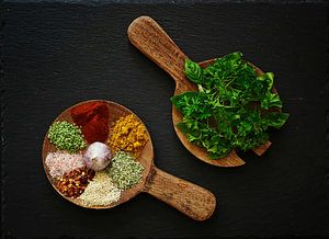 Heiteres Stilleben mit Gewürzen auf Holzlöffeln .
