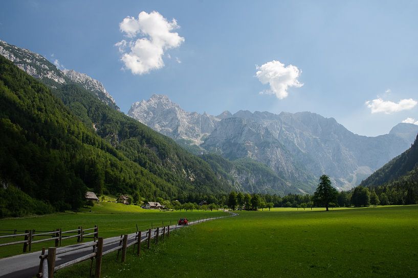 Red car drives down the road through the Logar Valley, Slovenia by Paul van Putten