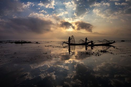 PÊCHEUR AT SUNRISE vist ON WAY TRADITIONNEL AU LAC INLE AU MYANMAR. Avec un panier du poisson est ca