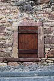 Boulder wall with brown shutter by Stadspronk