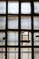 Zerbrochenes Fenster mit Gittern in einem verlassenen Gefängnis