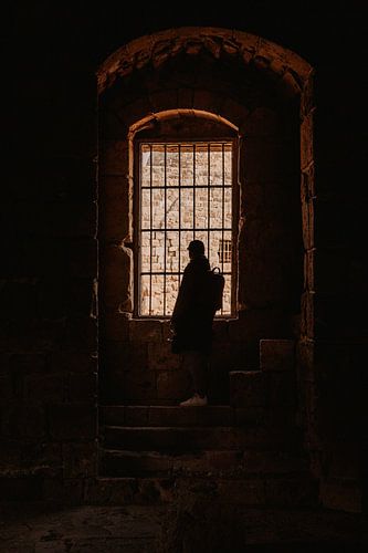 Man with cap in front of bars in a ruin of a castle in Sidon, Lebanon