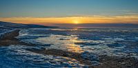 Zonsondergang bij een bevroren Waddenzee
