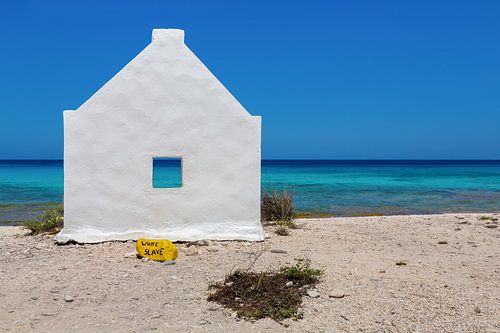 White slave house with text "White Slave" by the sea at the coast of Bonaire