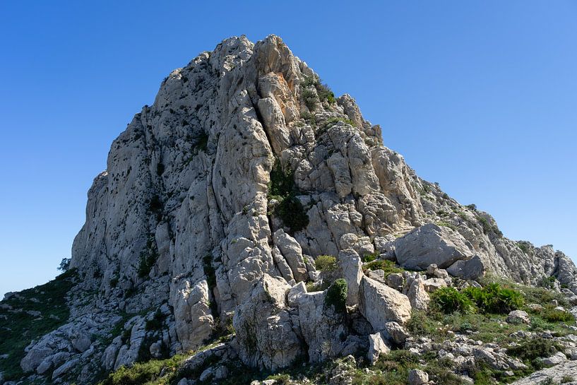 Rock formation of Cavall Verd under a blue sky by Adriana Mueller