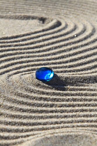 Traces in the sand with blue stone