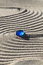 Sporen in het zand met blauwe steen van Karina Baumgart thumbnail