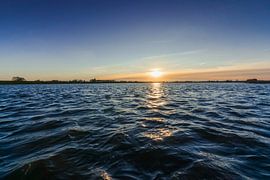 View from low point over the rippling water of a river by Fotografiecor .nl