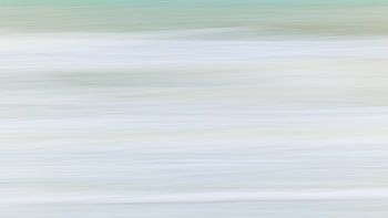 Into the blue. Soft hues of the North Sea waves in the winter morning light. Aspect ratio 16:9