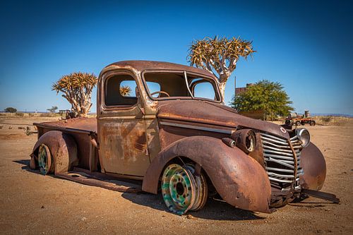 Een autowrak in de woestijn.