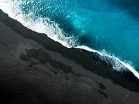 Schwarze Küste trifft auf azurblaues Meer