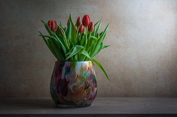 Stilleven met tulpen in een gekleurde glazen vaas