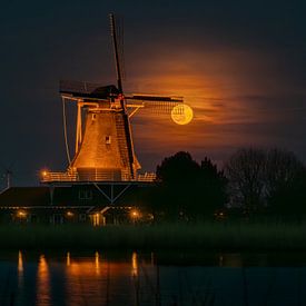 Volle maan schijnt door de wieken van molen De Leeuw in Anna Paulowna van Bram Lubbers