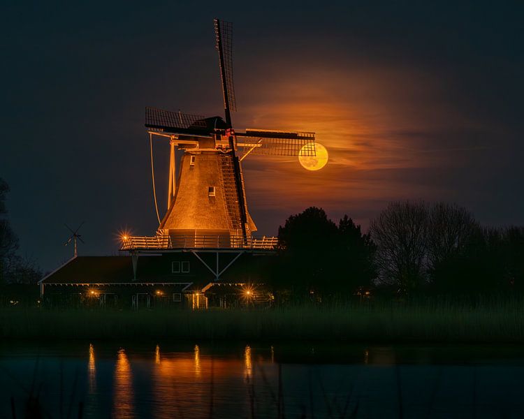 Volle maan schijnt door de wieken van molen De Leeuw in Anna Paulowna van Bram Lubbers