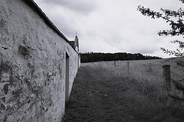 Zwart-wit beeld van verweerde muur in idyllisch landelijk landschap van Studio LE-gals
