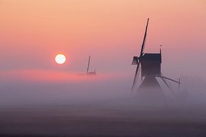 Molen in de mist tijdens zonsopkomst