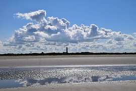 Bewölkter Himmel mit Leuchtturm auf Schier von Erik Buitenhuis