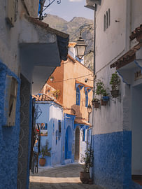 Gasse in Chefchaouen mit Bergen im Hintergrund von Lizet Wesselman