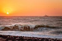 Golven op de dijk van Westkapelle tijdens zonsondergang