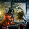Vrouw met olielamp die een grammofoonplaan op zet van Atelier Liesjes