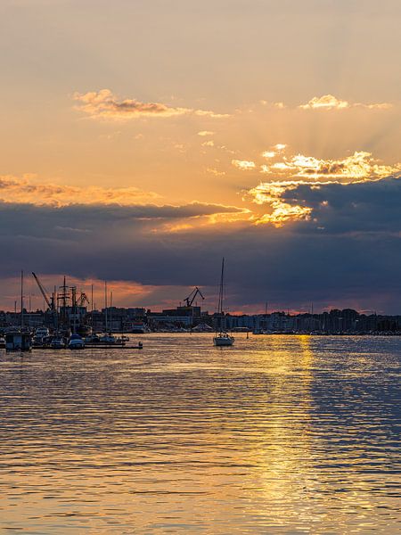 Zonsondergang met zeilboten in de haven van Rostock van Rico Ködder