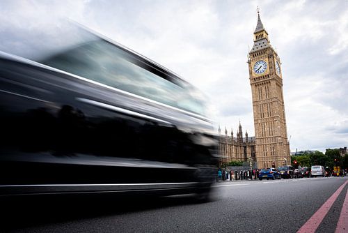 Londoner schwarzes Taxi mit Bewegungsunschärfe vor dem Palace of Westminster und Big Ben, London