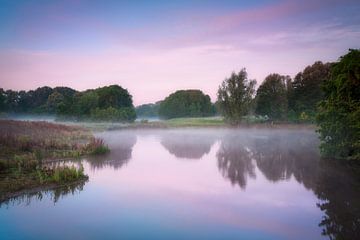 Sereen rivierlandschap bij zonsopgang met ochtendmist en rustige wateren van Original Mostert Photography