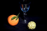 Apfelsine und Cherimoya mit blauem Weinglas