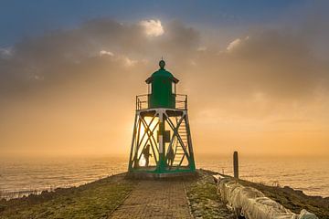 Foggy sunset at the Stavoren lighthouse by Harrie Muis