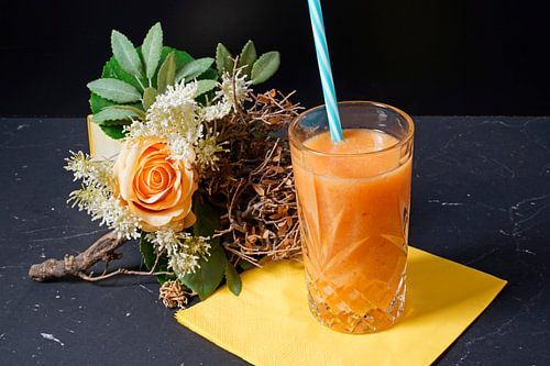 Sinaasappel papaya banaan smoothie in een glas.