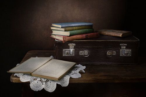 Modern stilleven van koffertje en oude boeken
