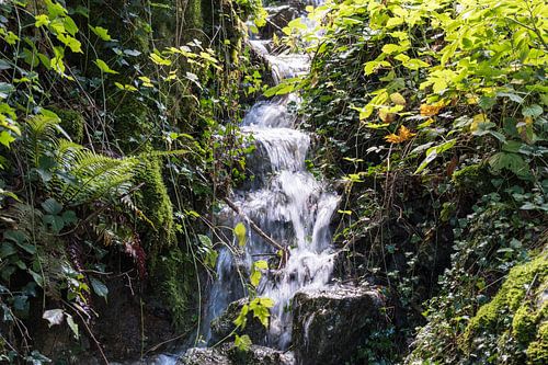 Waterval als stroompje uit de bergen tussen het groen