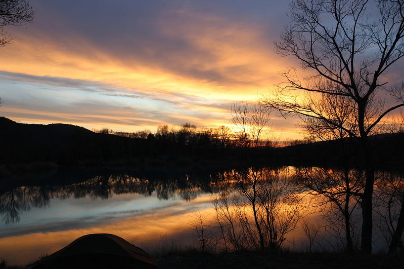 Most beautiful sunset reflected on a small lake in France by Inneke Heesakkers