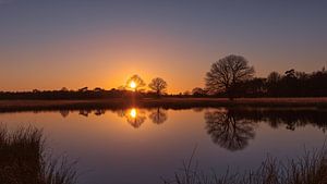 Doppelter Sonnenuntergang über dem Wasser