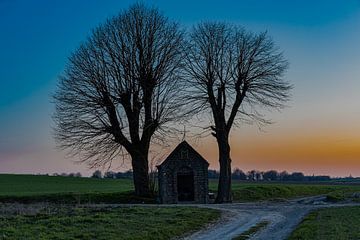 kapel midden in het weiland tijdens een kleurijke zonsondergang van Kim Willems