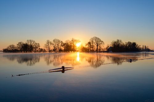 Zonsopgang over de IJssel tijdens een mistige koude winterochtend