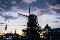 Comme le silence après la tempête, le moulin se dresse fièrement sur le ciel lourd du soir