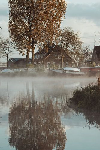 A boat on the water in the early morning, lying still in the cold mist and the soft dawn light