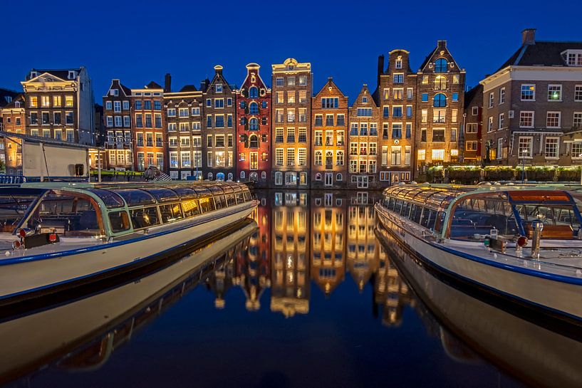Traditionele amsterdamse huizen en rondvaartboten in Amsterdam Nederland bij avond van Eye on You
